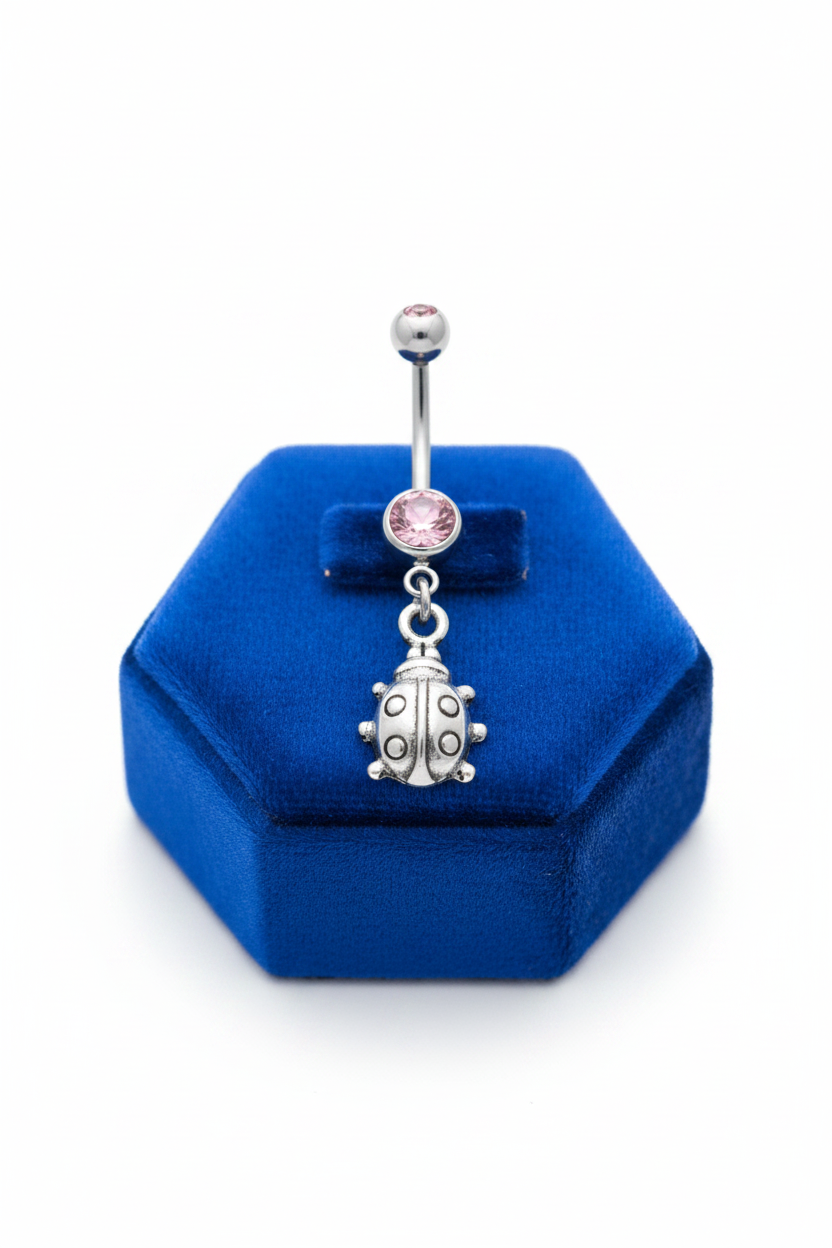 Pink Crystal Lady Bug Belly Button Ring in 316l stainless steel on a blue velvet jewelry display.
