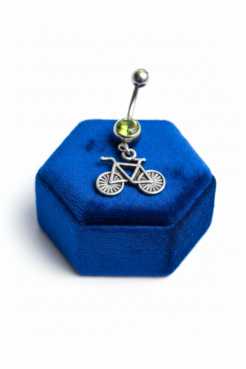 Green Crystal Bicycle Belly Button Ring in 316l stainless steel on a blue velvet jewelry display.