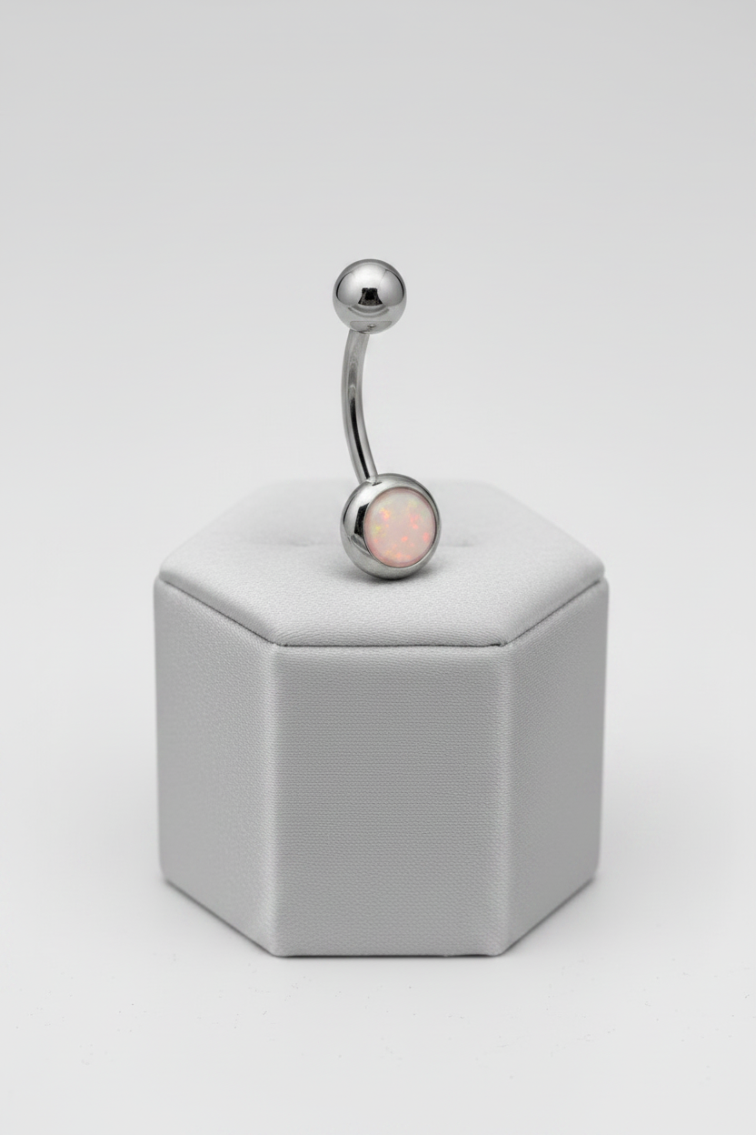 Pink Opal Belly Button Ring in 316l stainless steel on a silver silk jewelry display.