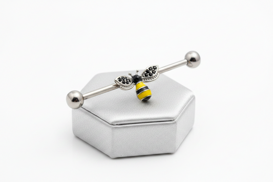Honey Bee Industrial Ear Barbell in 316l stainless steel on a silver jewelry display.