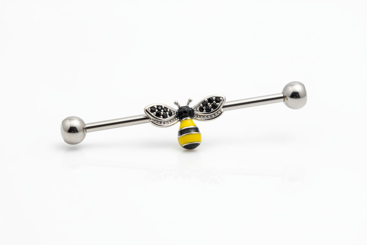 Honey Bee Industrial Ear Barbell in 316l stainless steel on a white background in close up detail.