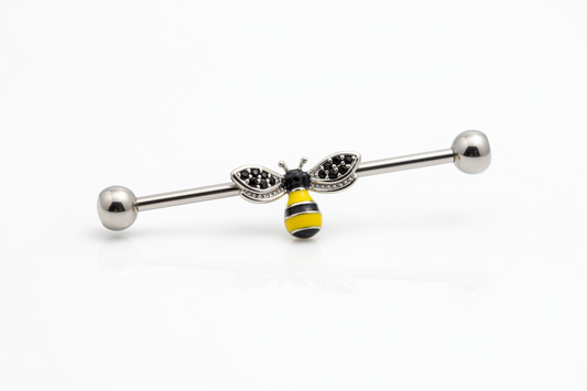 Honey Bee Industrial Ear Barbell in 316l stainless steel on a white background in close up detail.