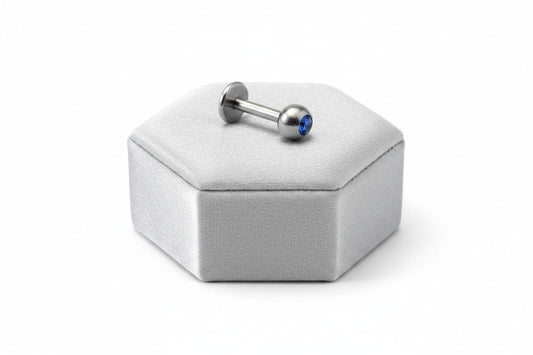 Navy Blue Crystal Labret Lip Ring in 316l stainless steel on a silver silk jewelry display.