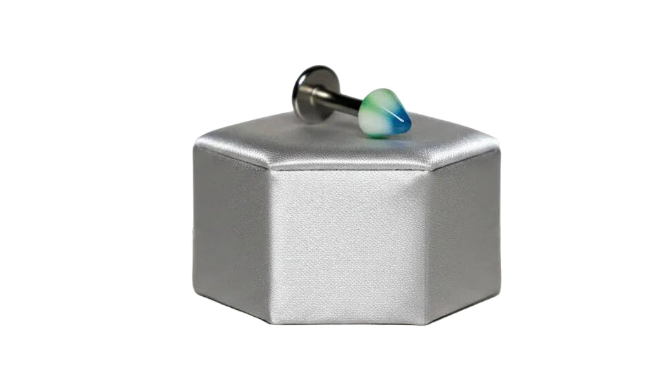 Green Striped Acrylic Spike Labret Lip Ring in 316l stainless steel on a silver silk jewelry display in close up detail.