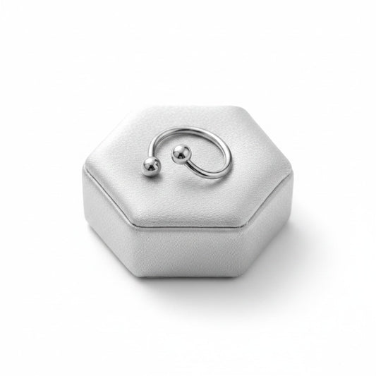 Multi-Purpose Steel Curled Barbell in 316l stainless steel on a silver silk jewelry display.