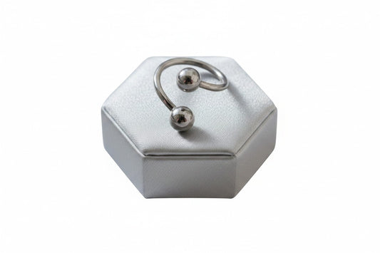 Versatile Steel Curled Barbell in 316l stainless steel on a silver silk jewelry display.