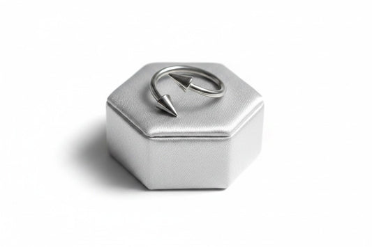 Multi-Purpose Steel Spike Curled Barbell in  316l stainless steel on a silver silk jewelry display.