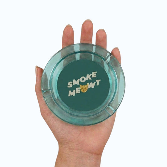 Funny Cat Face "Smoke Meowt" 3 Inch Glass Ashtray on a white background being held up in a models hand showing full cat design detail.