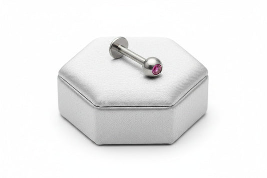 Fuchsia Pink Crystal Labret Lip Ring in 316l stainless steel on a silver silk jewelry display.