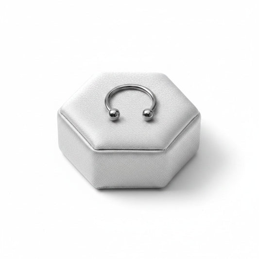 Versatile Steel Horseshoe Curved Barbell in 316l stainless steel on a silver silk jewelry display in close up detail.