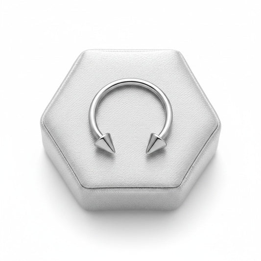 Spiked Steel Horseshoe Curved Barbell in 316l stainless steel on a silver silk jewelry display.