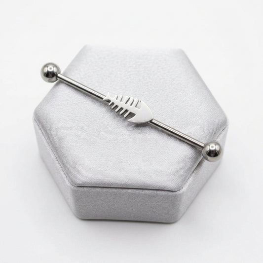 Fishbone Industrial Ear Barbell in 316l stainless steel on a silver silk jewelry display.