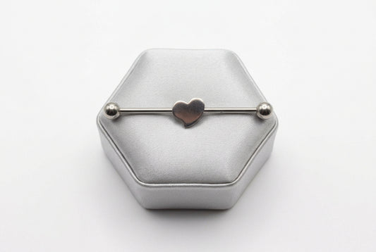 Heart Industrial Ear Barbell in 316l stainless steel on a silver silk jewelry display.