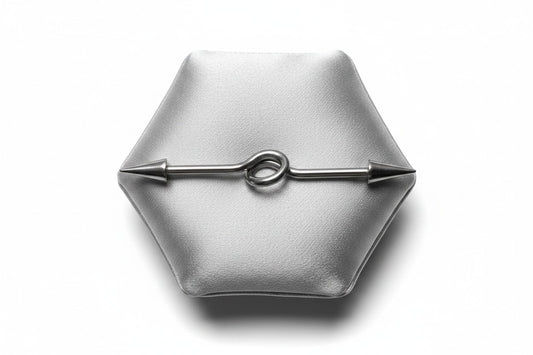Industrial Ear Barbell with Spikes in 316l stainless steel on a silver silk jewelry display.
