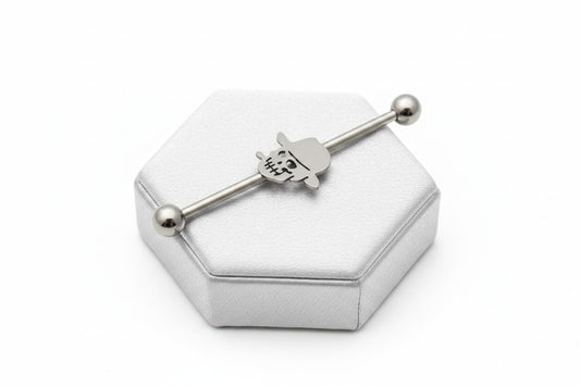 Skull Head Industrial Ear Barbell - 316L Stainless Steel on a silver silk jewelry display.