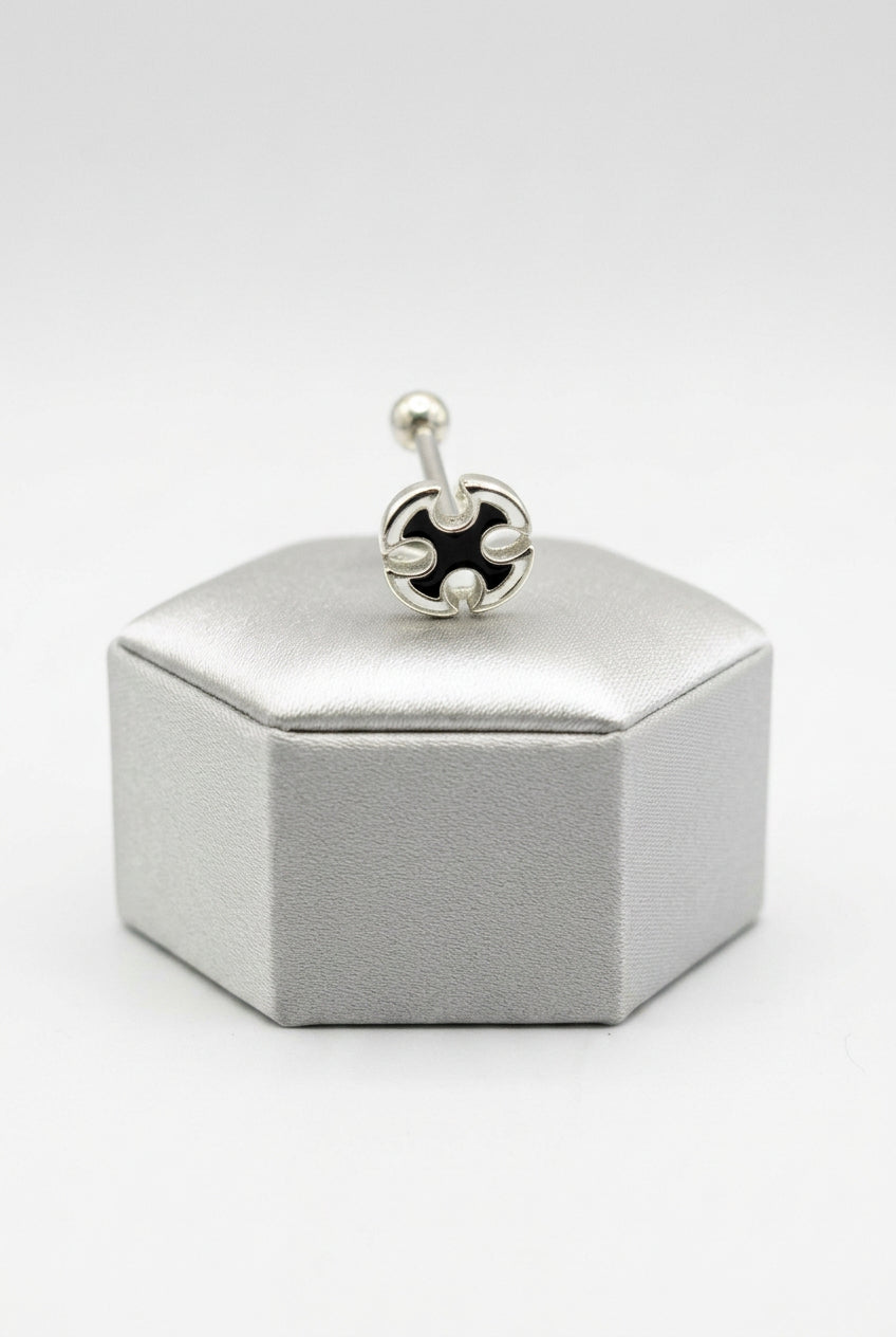 Maltese Cross Tongue Piercing in 316l stainless steel on a silver silk jewelry display.
