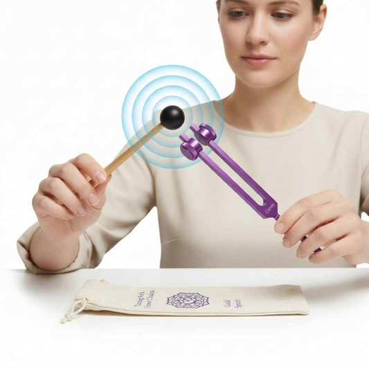 Purple Crown Chakra Aluminum Tuning Fork With Silencers 172.06 Hz being held by a female model and actively struck showing sound waves.