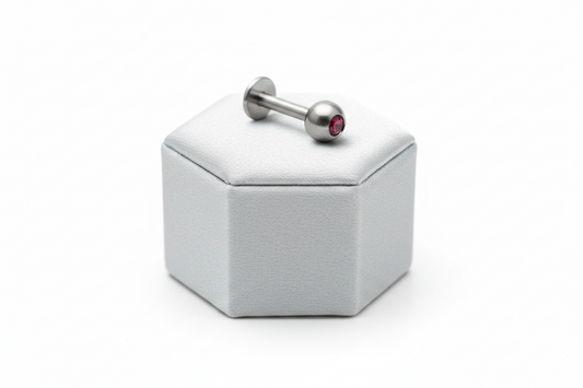 Red Crystal Labret Lip Ring in 316l stainless steel on a silver silk jewelry display.