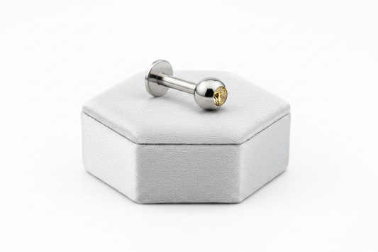 Yellow Crystal Labret Lip Ring in 316l stainless steel on a silver silk jewelry display.