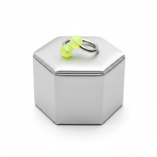 Yellow Glow Acrylic Curled Barbell in 316l stainless steel on a silver silk jewelry display.