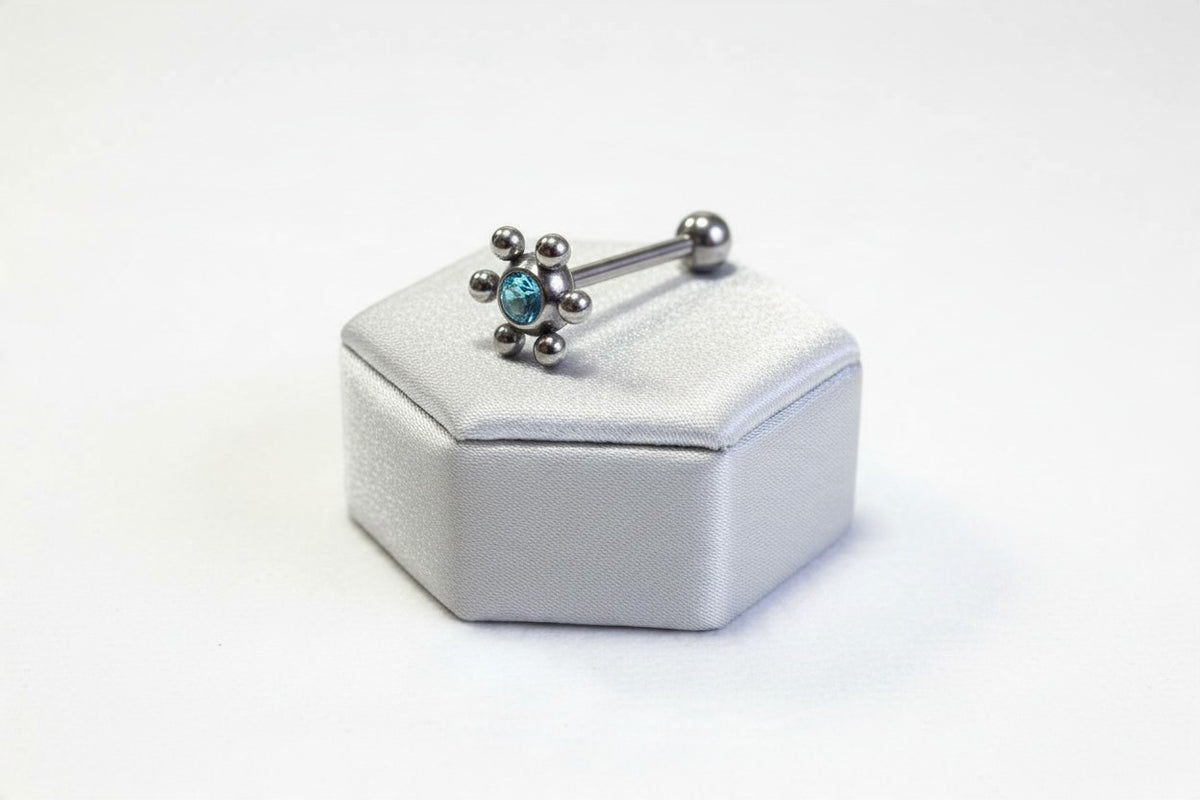 Aqua Crystal Decorative Tongue Barbell in 316l stainless steel on a silver silk jewelry display.