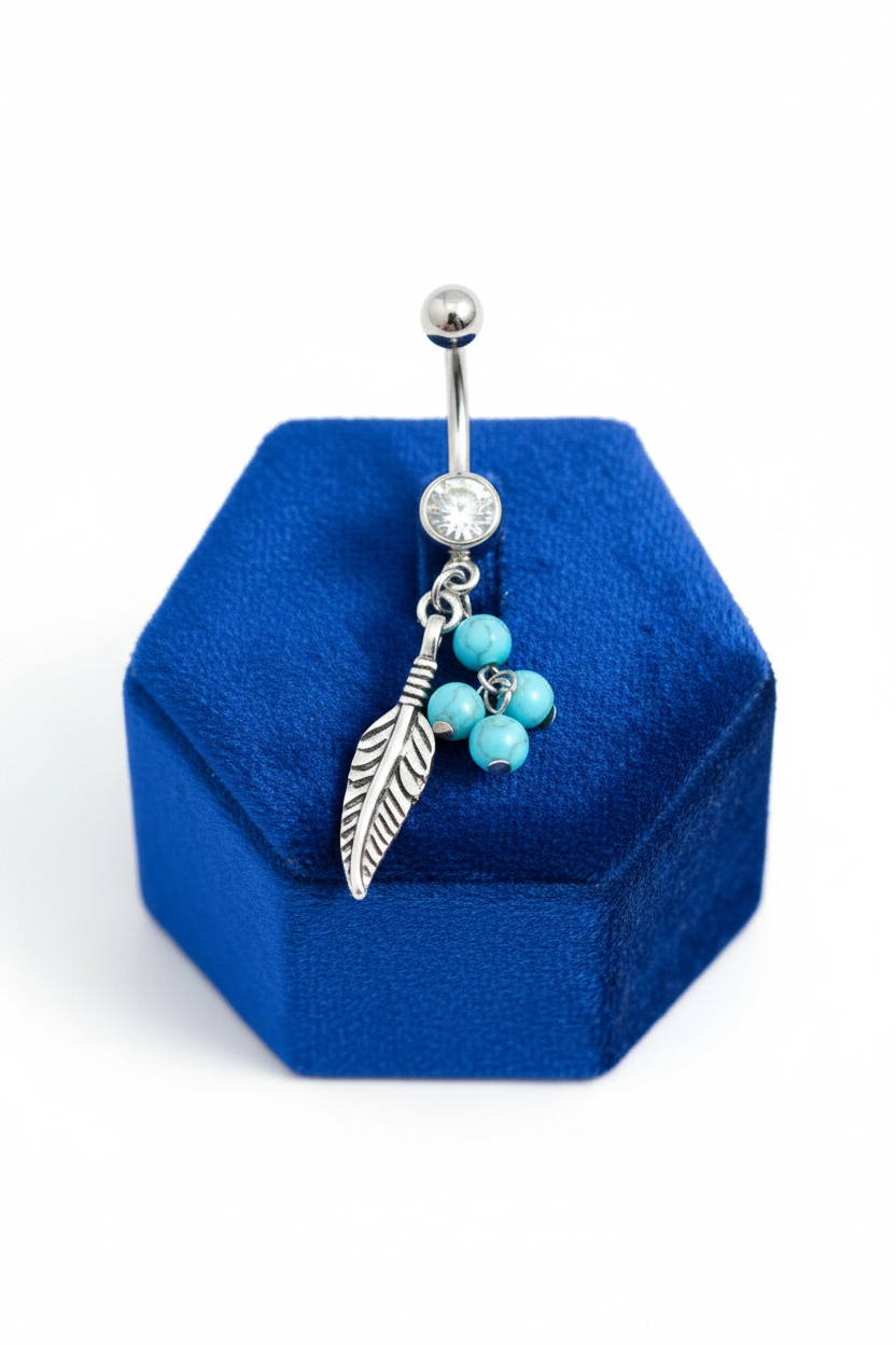 Clear Crystal Turquoise Feather Belly Button Ring in 316l stainless steel on a blue velvet jewelry display.