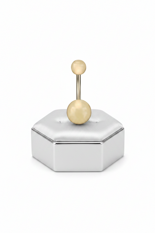 Peach Glow Acrylic Belly Button Ring in 316l stainless steel on a silver jewelry display.