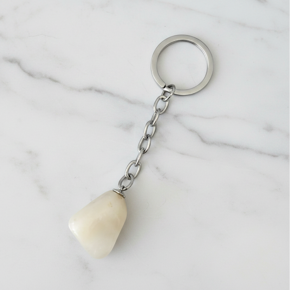 Opaque White Quartz Natural Earth Stone Handmade Steel Plated Keychain on a white marble surface.