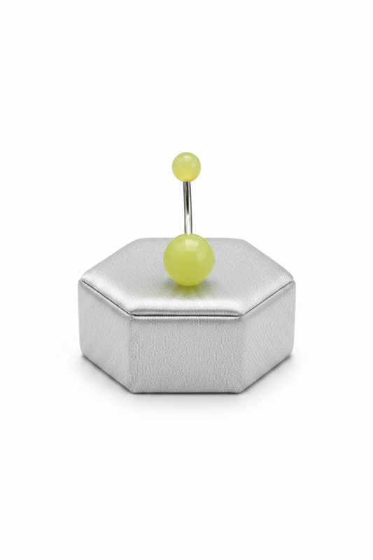 Yellow Glow Acrylic Belly Button Ring in 316l stainless steel on a silver jewelry display.