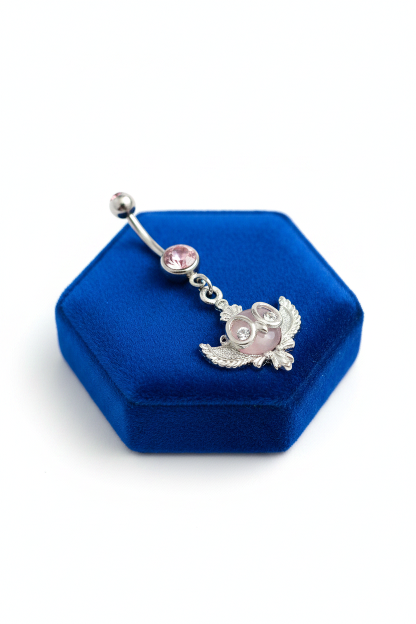 Pink Crystal Owl Belly Button Ring in 316l stainless steel on a blue velvet jewelry display.