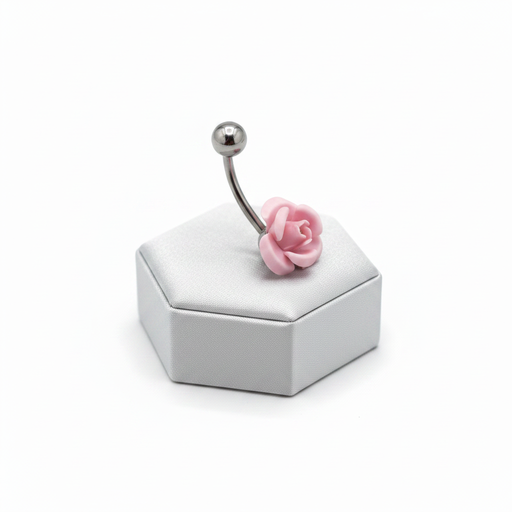 Pink Rose Curved Barbell Belly Button Ring in 316l stainless steel on a silver jewelry display side view.