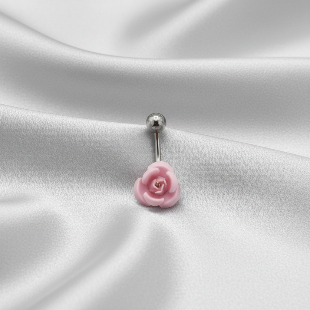 Pink Rose Curved Barbell Belly Button Ring in 316l stainless steel on silver silk fabric.