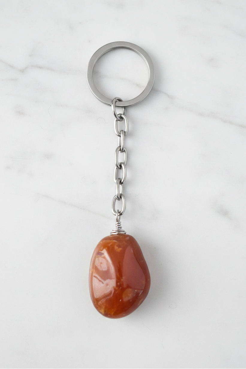 Carnelian Natural Earth Stone Handmade Steel Plated Keychain on a white marble surface.