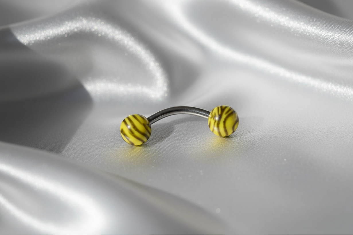 Yellow and Black Tiger Striped Acrylic Eyebrow Ring in 316l stainless steel.