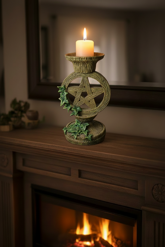 Green Pagan Pentagram Star Resin Candle Holder on a fireplace mantle with a burning fire and the candle lit showing a warm glow.