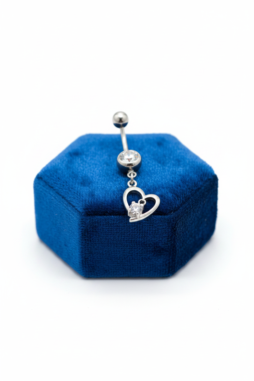 Clear Crystal Heart Belly Button Ring in 316l stainless steel on a blue velvet jewelry display.