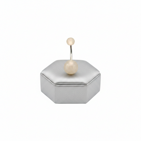 White Glow Acrylic Belly Button Ring in 316l stainless steel on a silver jewelry display.