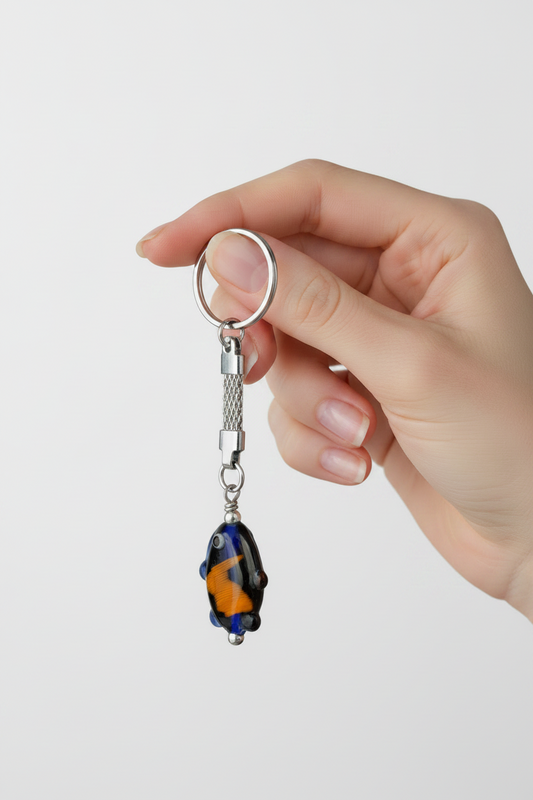Blue Glass Fish Steel Plated Handmade Keychain held by a models hand showing scale.
