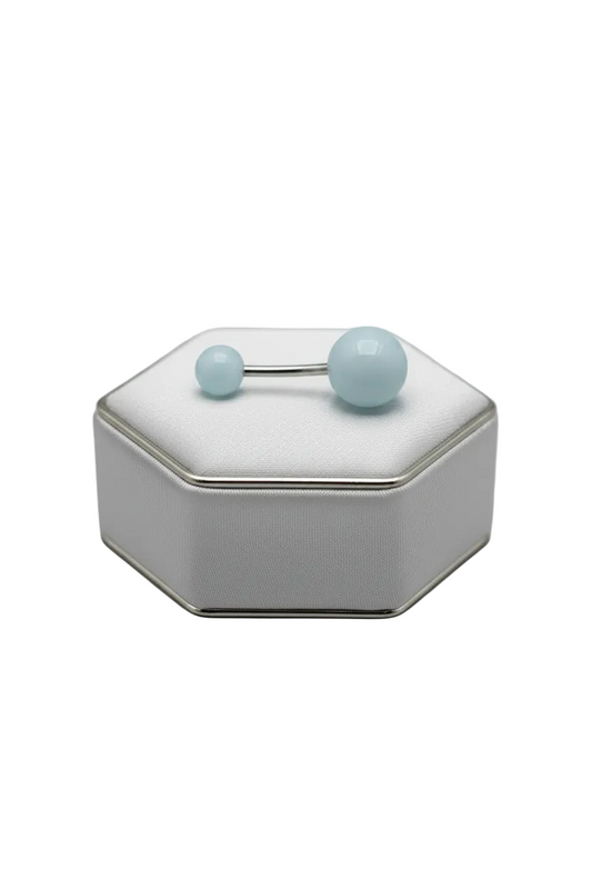 Blue Glow Acrylic Belly Button Ring in 316l stainless steel on a silver jewelry display horizontal angle.