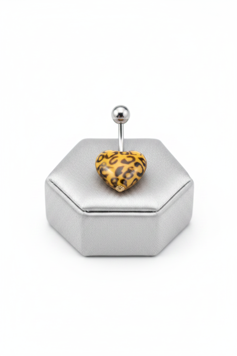 Orange Leopard Print Heart Acrylic Belly Button Ring in 316l stainless steel on a silver jewelry display.