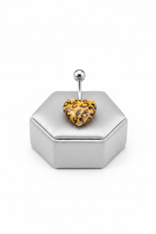 Orange Leopard Print Heart Acrylic Belly Button Ring in 316l stainless steel on a silver jewelry display.