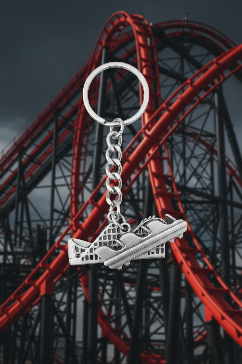 Rollercoaster Ride Handmade Pewter Charm Keychain with a black and red roller coaster in the  background.