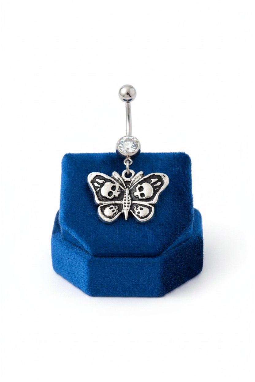 Clear Crystal Skull Butterfly Belly Button Ring in 316l stainless steel on a blue velvet jewelry display.