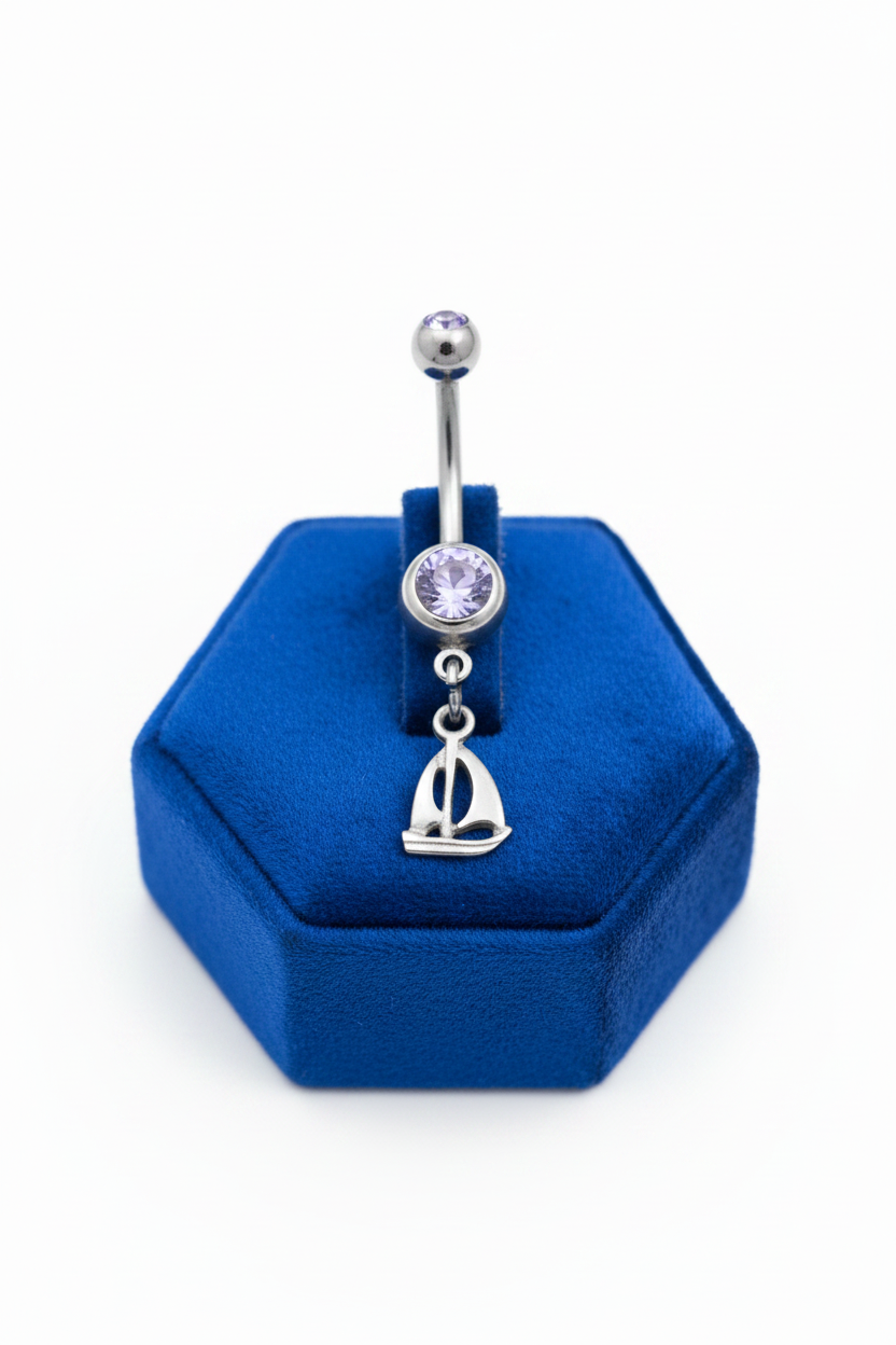 Purple Crystal Sterling Silver Sailboat Belly Button Ring in 316l stainless steel on a blue velvet jewelry display.