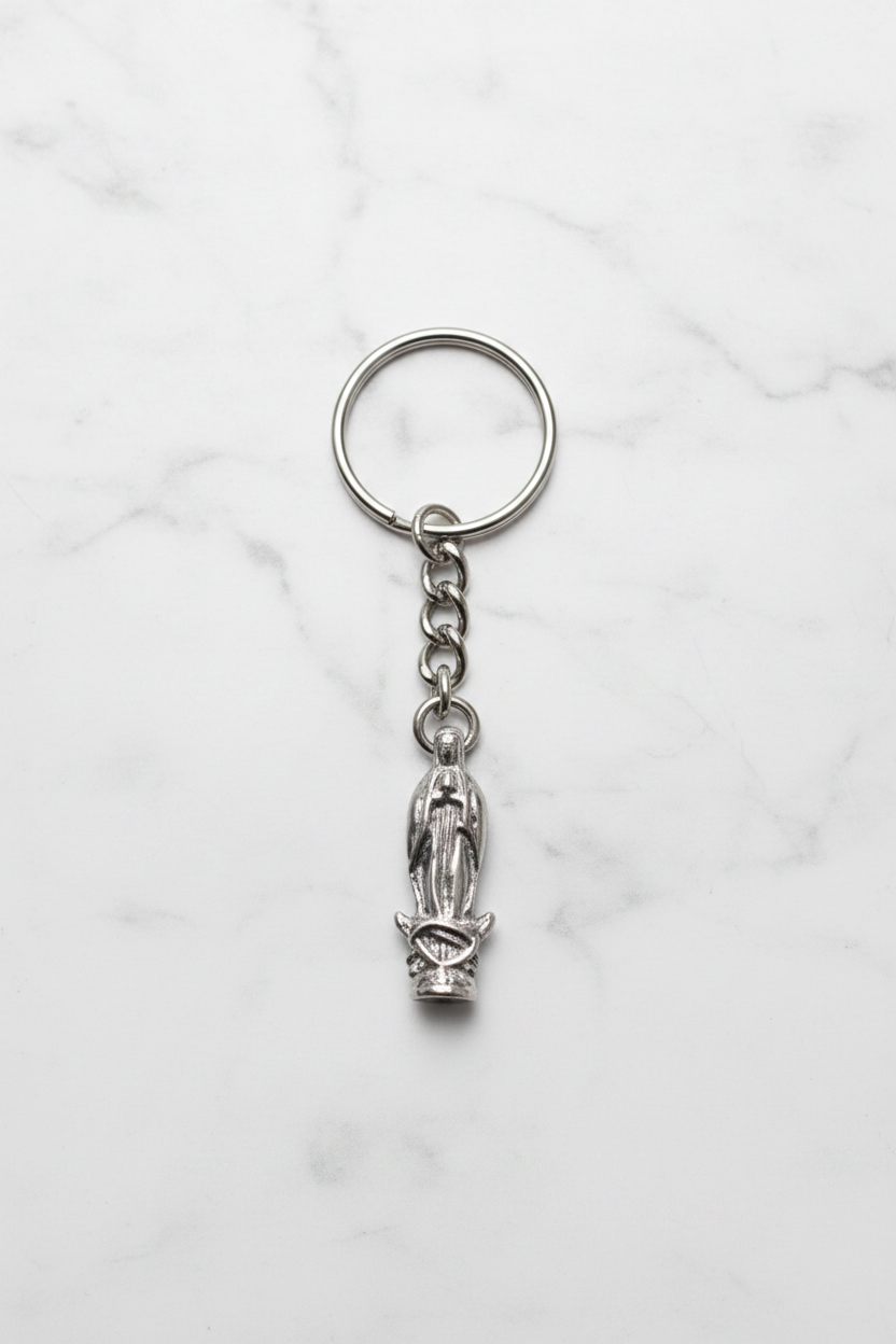 Virgin Mary Handmade Pewter Charm Keychain on a white marble surface.