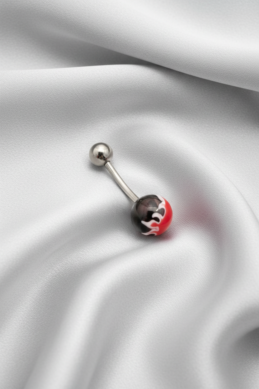 Red Fireball Acrylic Belly Button Ring in 316l stainless steel on a silver silk fabric.