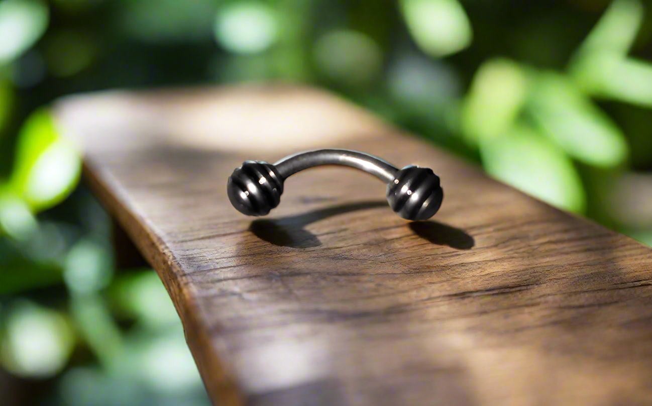 Steel Eye Brow Piercing with Black Striped Ball Ends