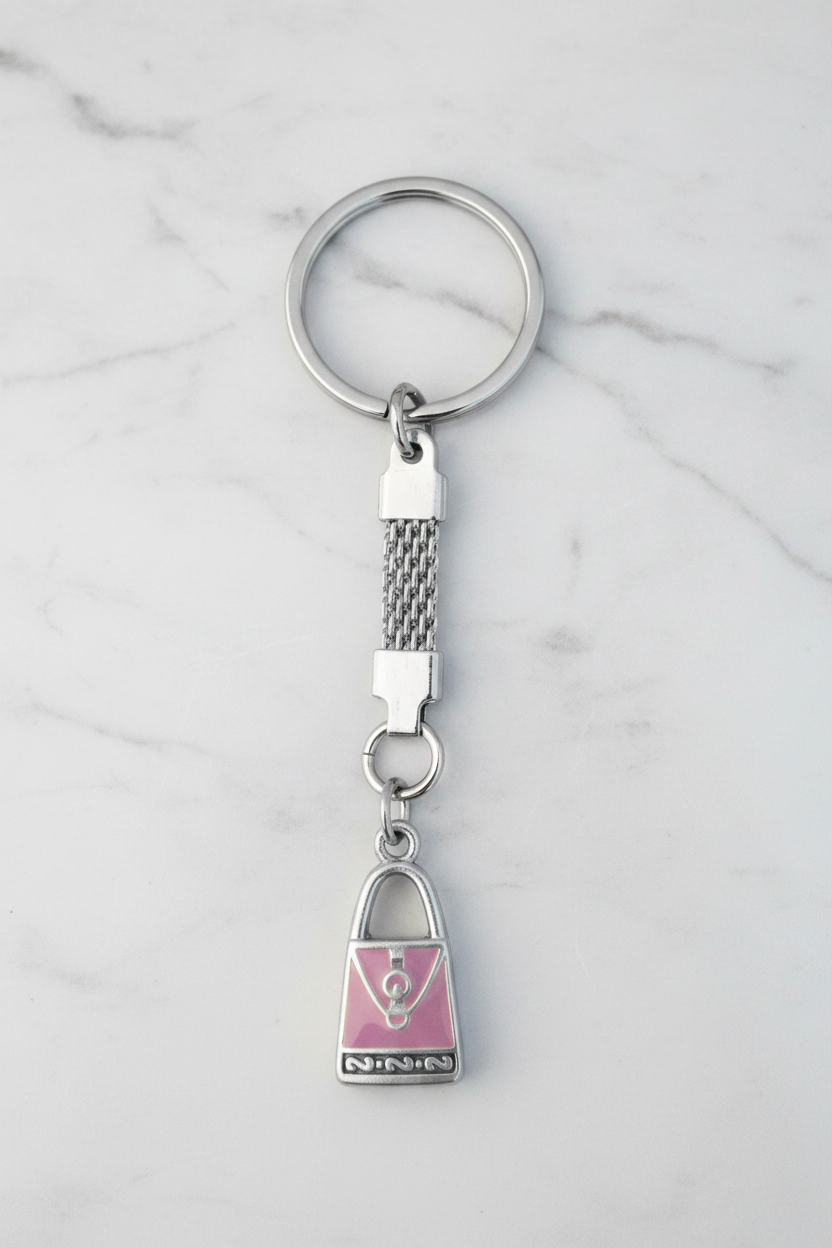 Purple Enamel Purse Handmade Silver Plated Charm Keychain on a white marble surface.