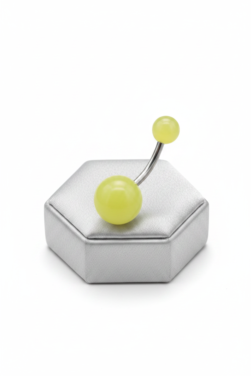 Yellow Glow Acrylic Belly Button Ring in 316l stainless steel on a silver silk jewelry display.