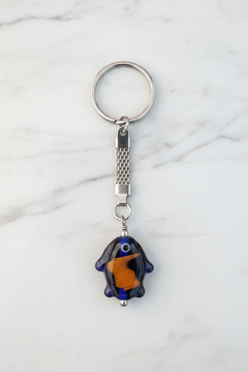 Blue Glass Fish Steel Plated Handmade Keychain on a white marble surface.